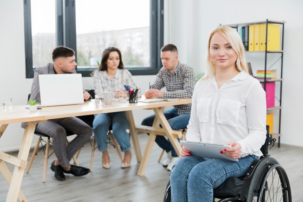 Nos Formations Inclusion et accessibilité en formation : stagiaire en fauteuil roulant participant à un atelier collaboratif - CYMP Formation