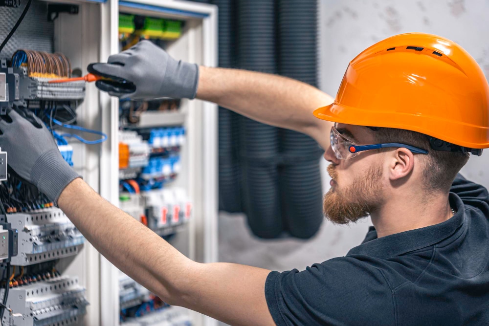 Électricien avec casque de sécurité intervenant sur une armoire électrique lors d'une formation habilitation électrique - CYMP Formation